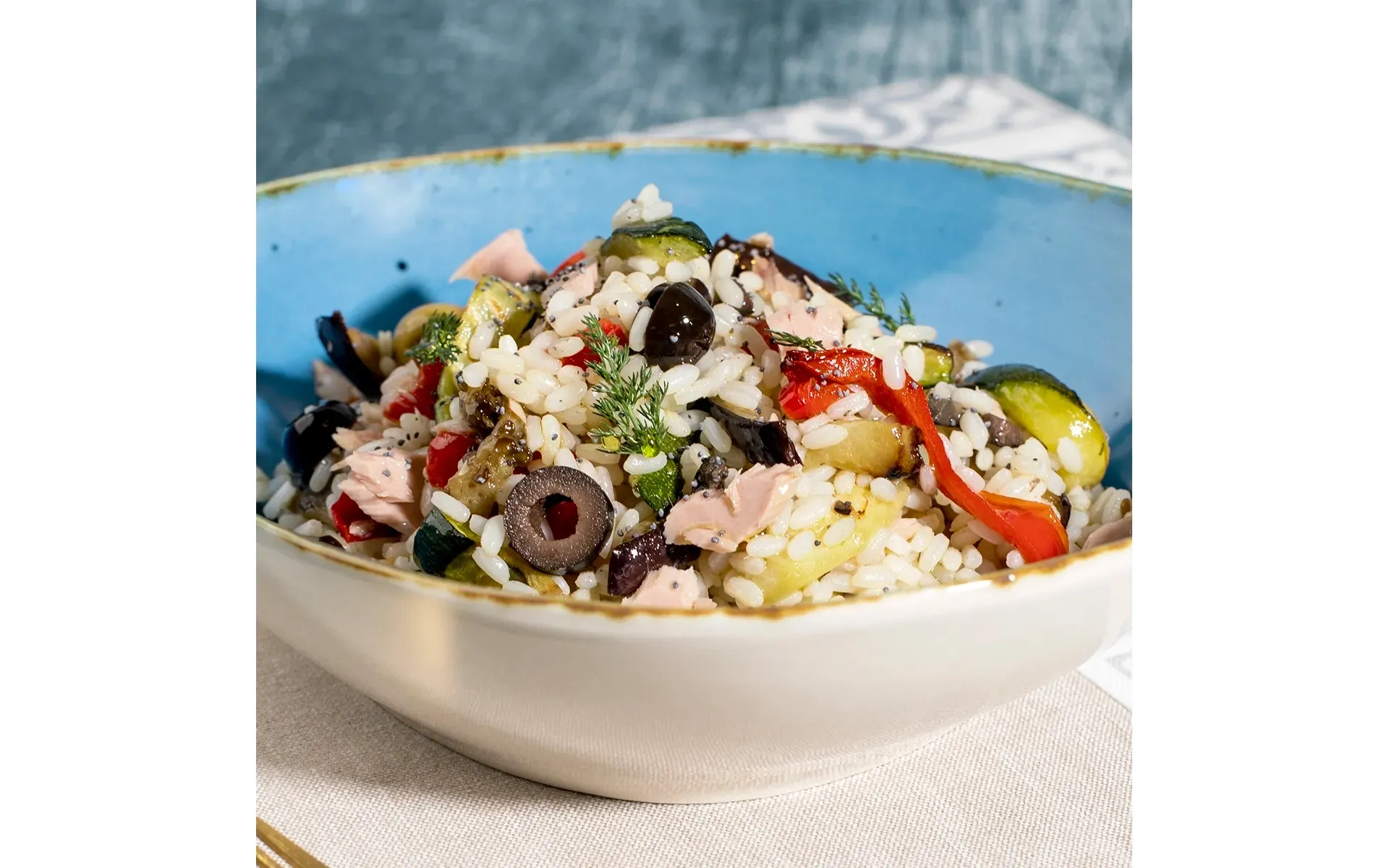 Ciotola colorata di insalata di riso, un classico estivo fresco e gustoso, con verdure miste.