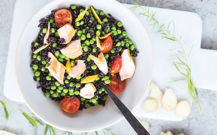 Come cucinare i piselli surgelati Orogel: una ciotola di riso nero con piselli dolci e salmone fresco.