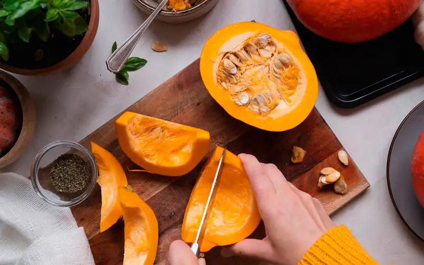 Come cucinare la zucca Orogel: dalla padella al forno. Persona che taglia una zucca a pezzi.