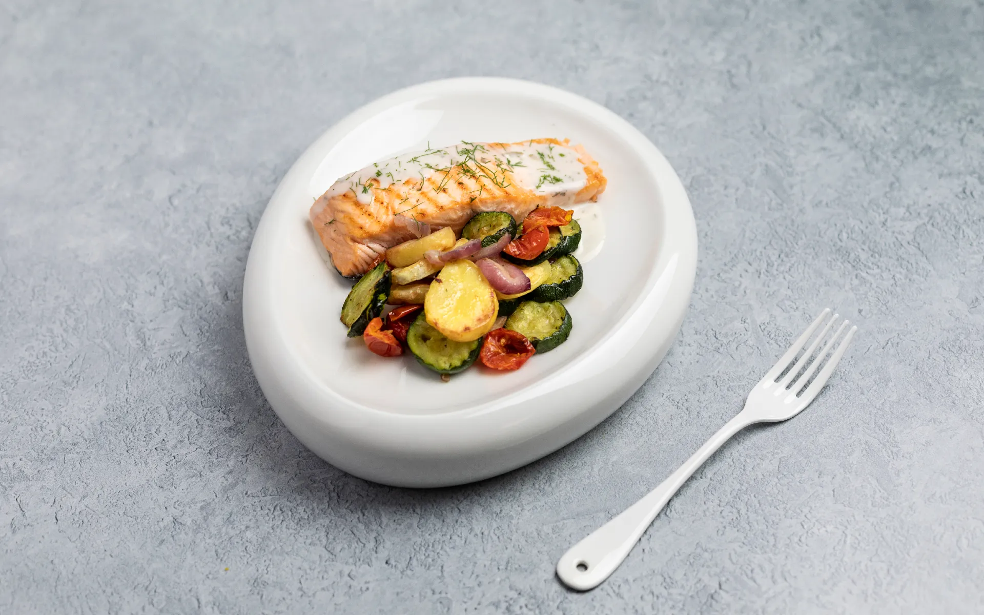 Trancio di salmone al forno servito con un colorato Contorno Fantasia Orogel a base di verdure.