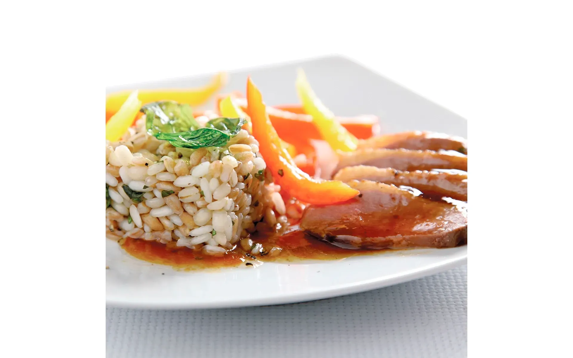 Anatra laccata al miele, un secondo piatto gourmet, servita con riso e verdure fresche Orogel.