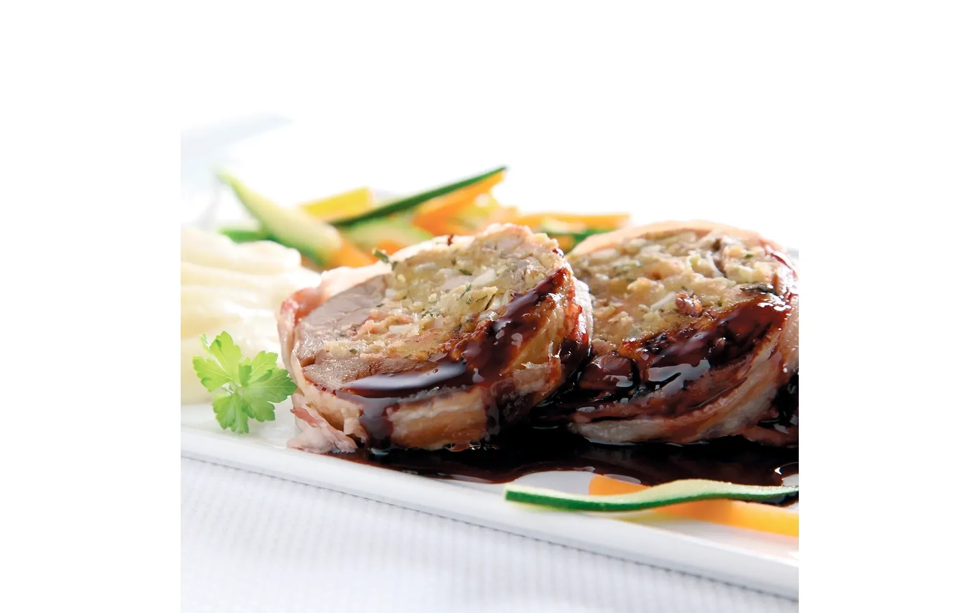 Piccione torresano, una specialità tradizionale, qui servito con una salsa ricca e verdure Orogel.