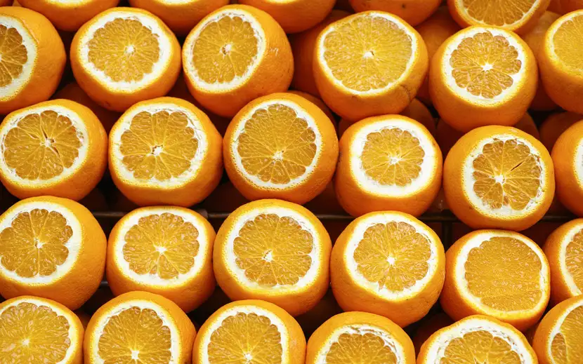 Scopri come profumare casa con bucce d'arancia: un mucchio di arance fresche, una tagliata a metà.