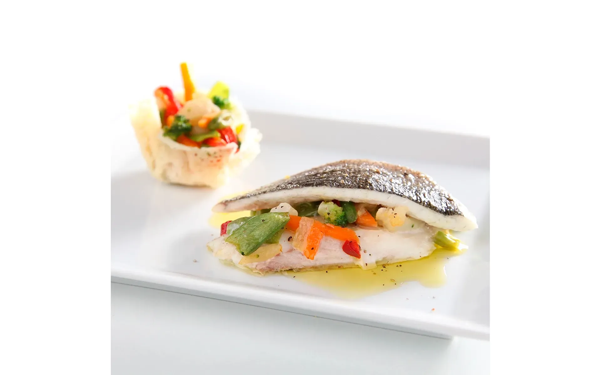 Sandwich Orogel farcito con ingredienti freschi e di qualità, come pesce e verdure, su piatto bianco.