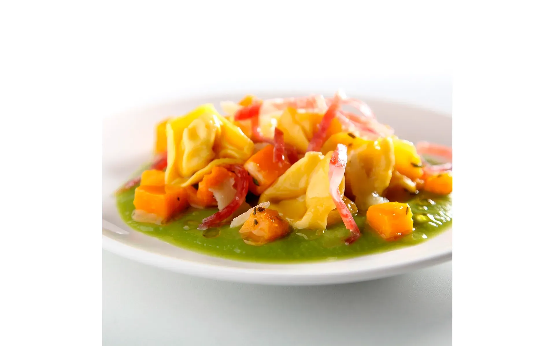 Piatto elegante di tortelloni ripieni, accompagnati da un contorno di verdure fresche.