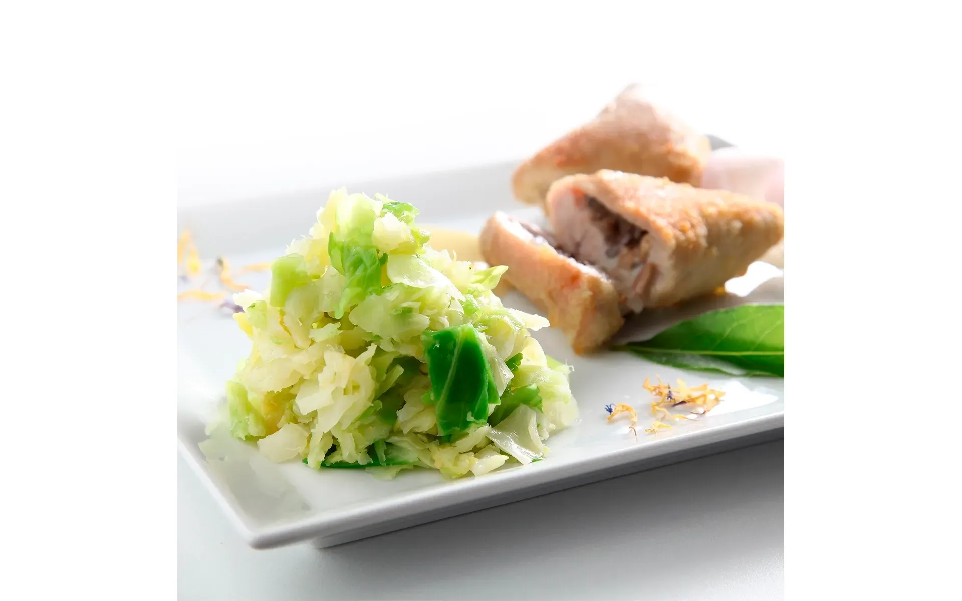 Triangoli Orogel (pasta ripiena o snack), serviti su un piatto bianco con pollo e insalata verde.