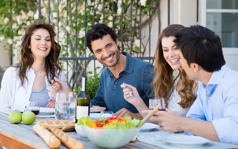 Millennials: come conquistare il pubblico. Gruppo di giovani che mangiano all'aperto, socializzando.