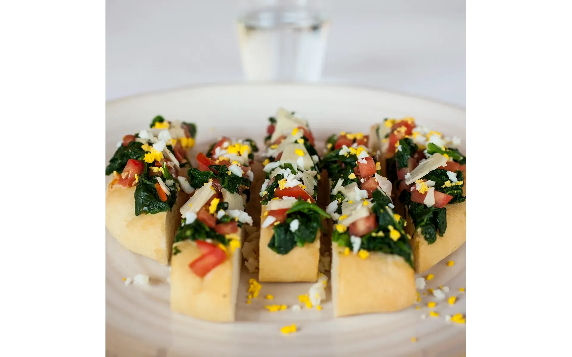 Focaccia con spinaci Orogel, soffice e gustosa, servita su un piatto, magari con un bicchiere d'acqua.