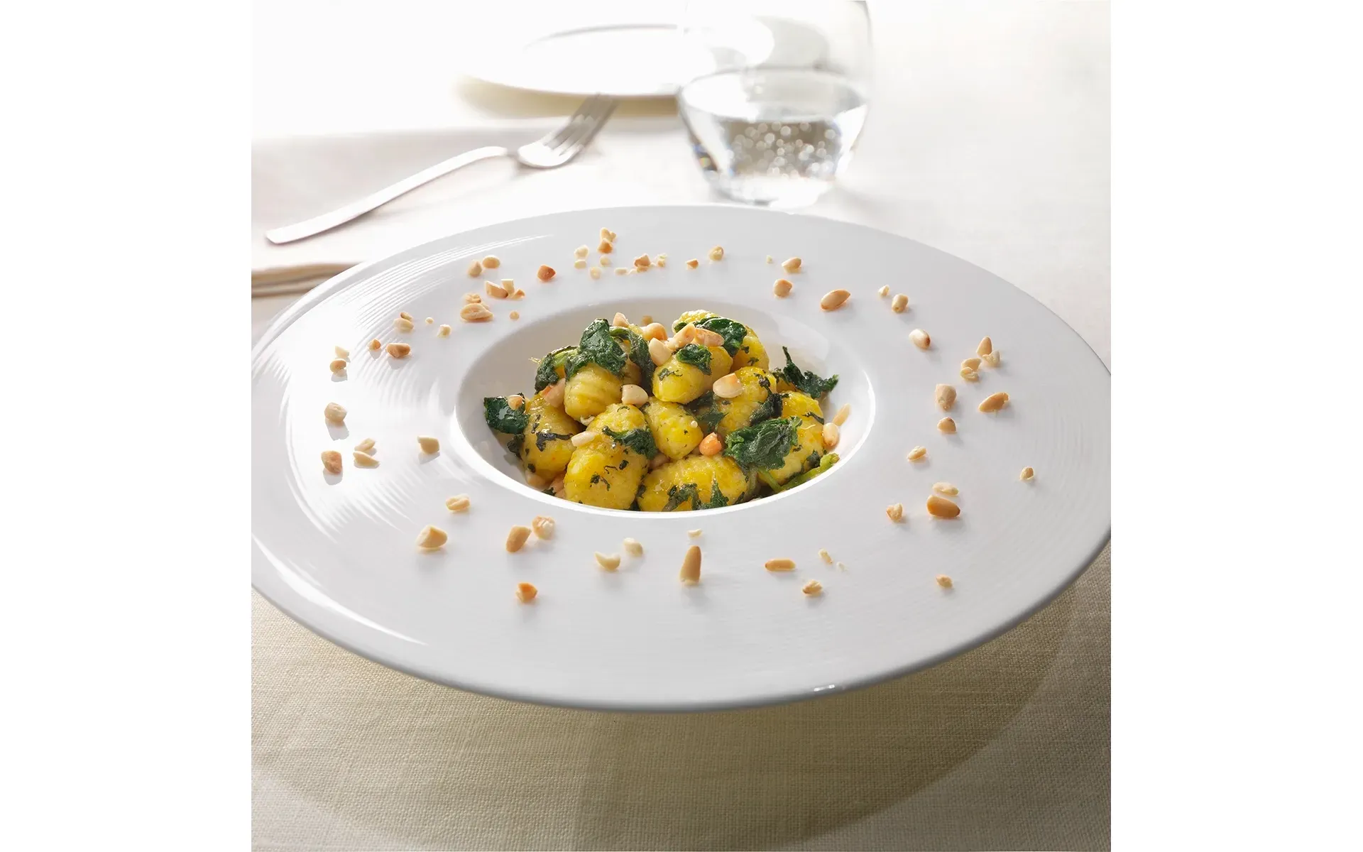 Gnocchi di patate Orogel con zafferano, un primo piatto elegante e profumato, servito su piatto bianco.