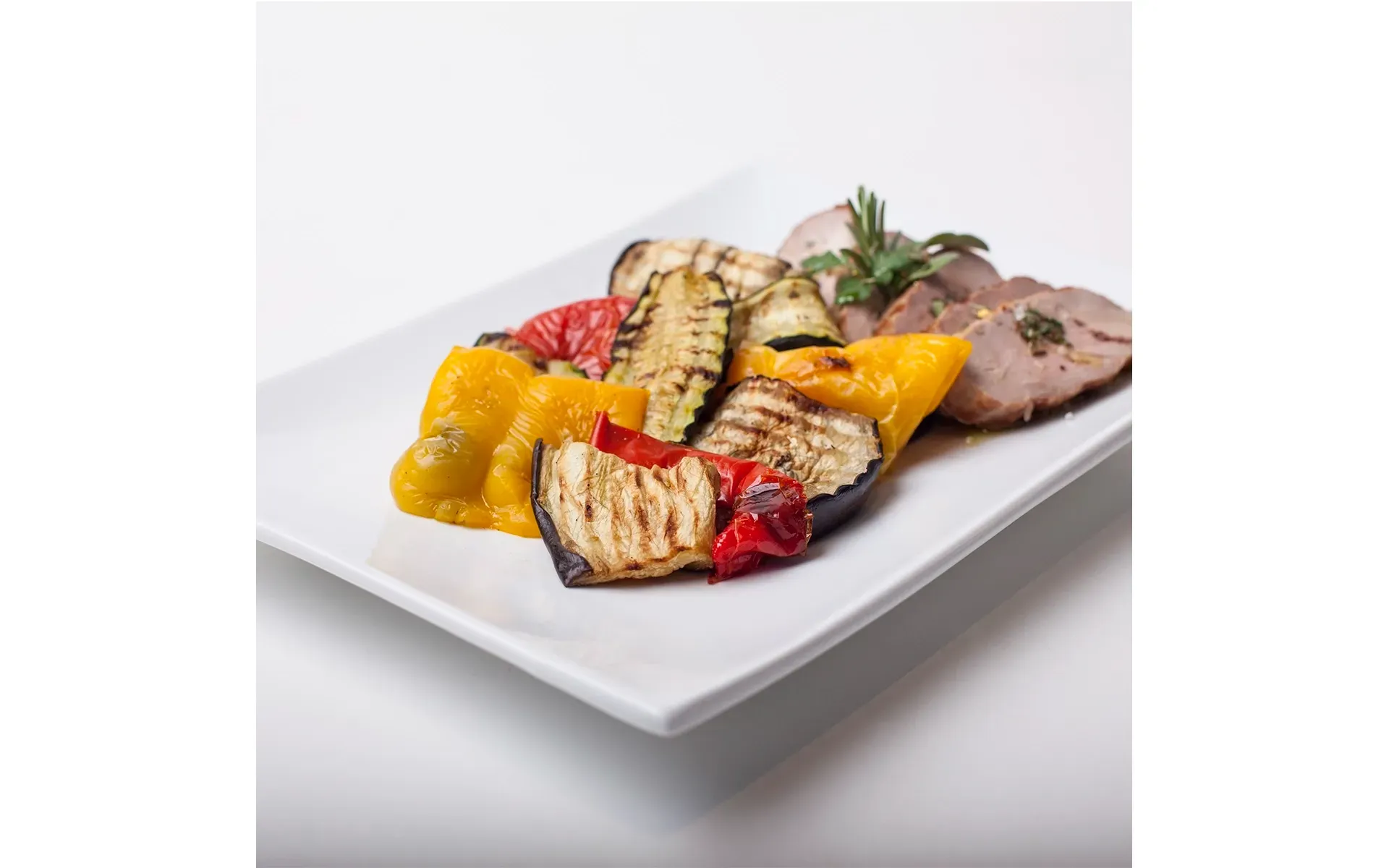 A plate of tender roast veal with a side of Orogel BBQ Grilled Vegetables.