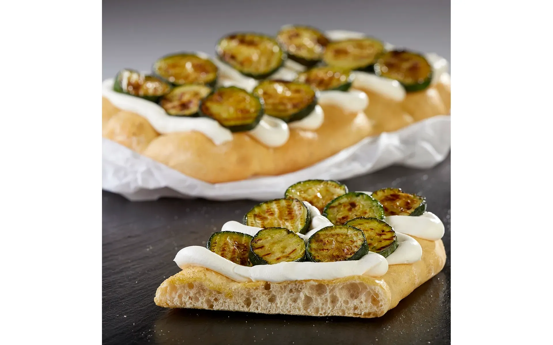 Schiacciatina Orogel farcita con zucchine grigliate e formaggio filante, uno snack gustoso.
