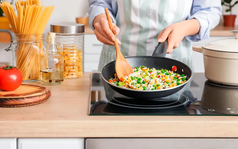 Come preparare il piatto unico perfetto: una donna cucina verdure fresche Orogel in padella.