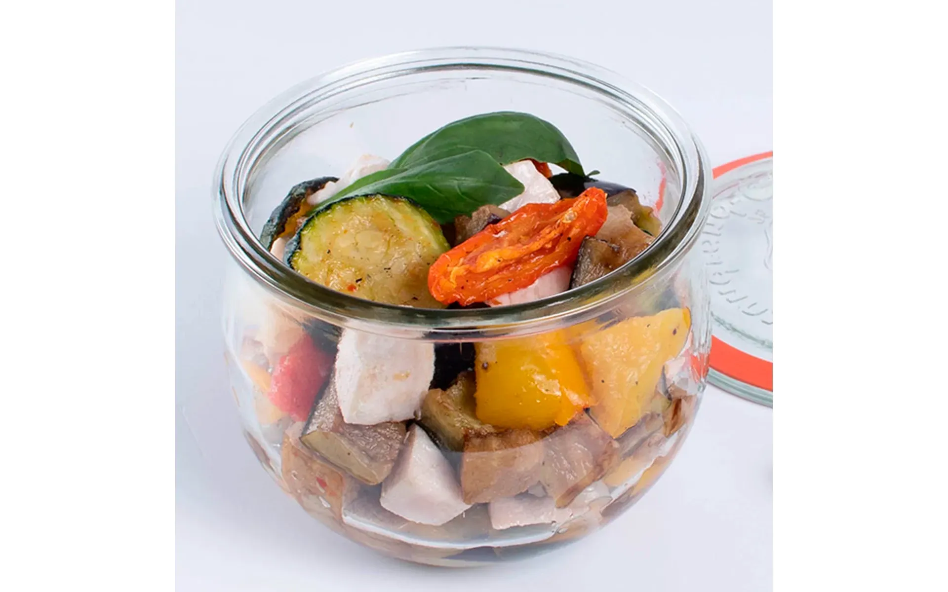 Barattolo di vetro con una preparazione a base di verdure e carne, pronta da gustare.