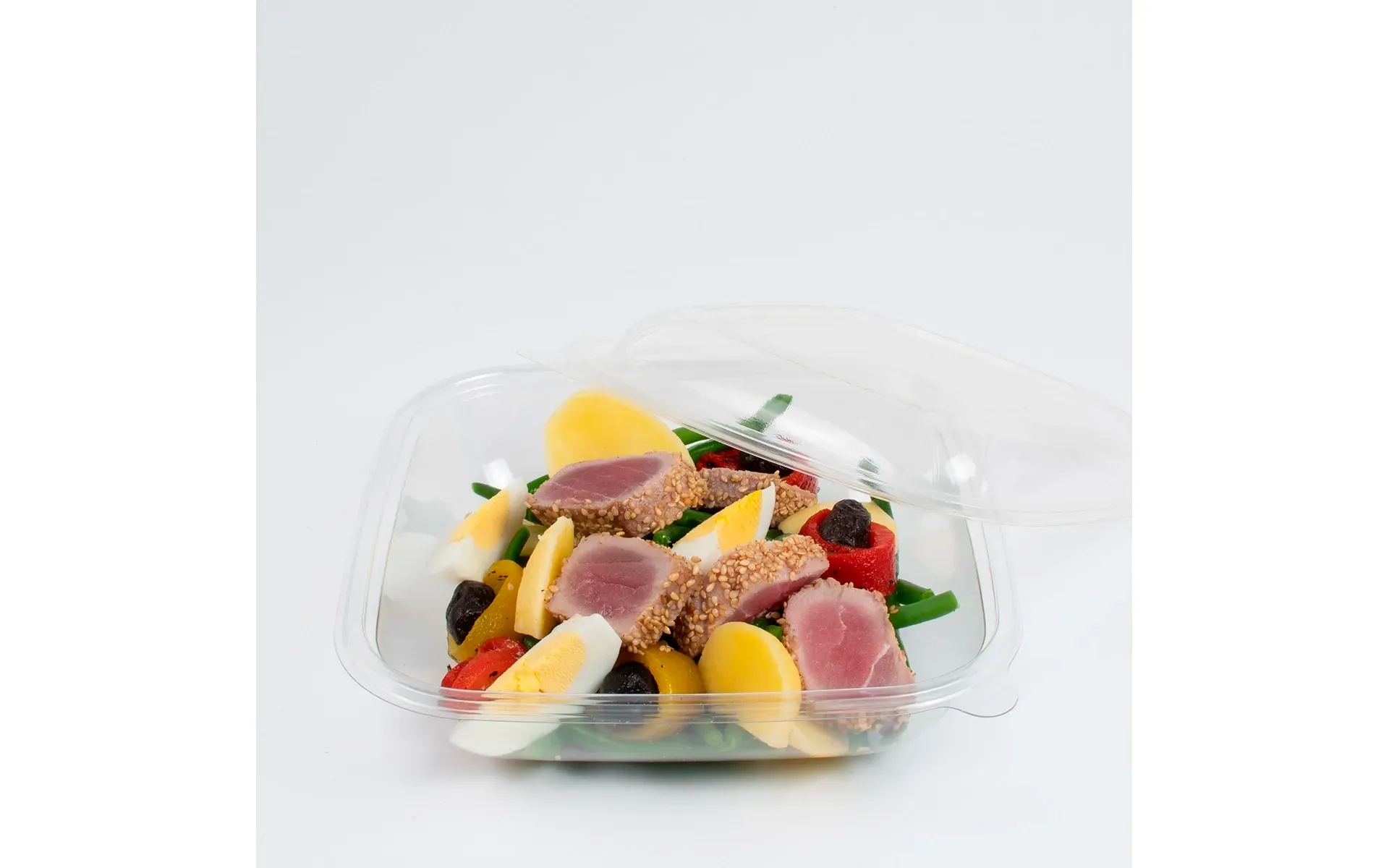 Contenitore di plastica con un pasto completo Orogel, con frutta e carne, pronto da consumare.