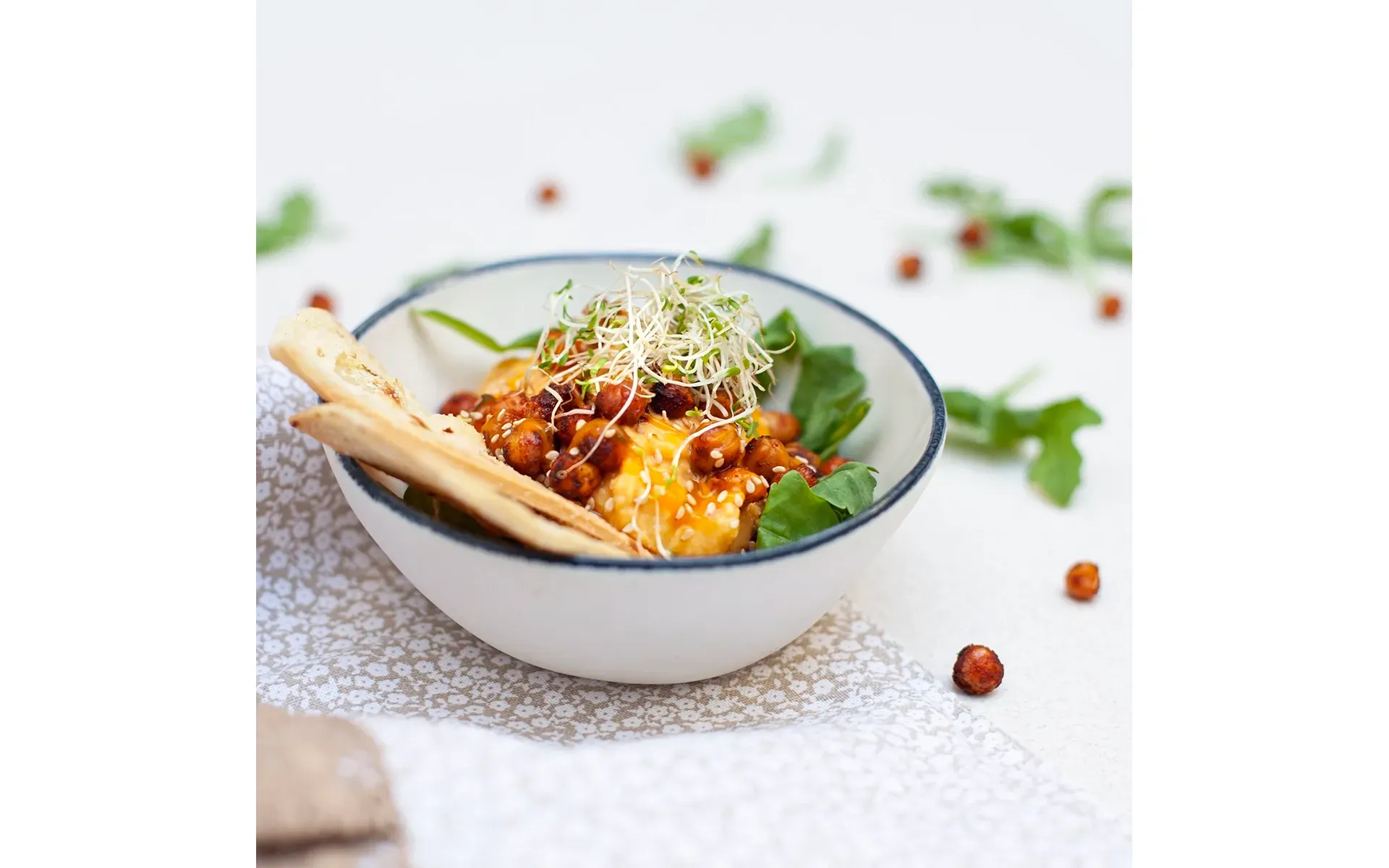 Hummus Orogel cremoso e saporito, servito in una ciotola con un filo d'olio e spezie.