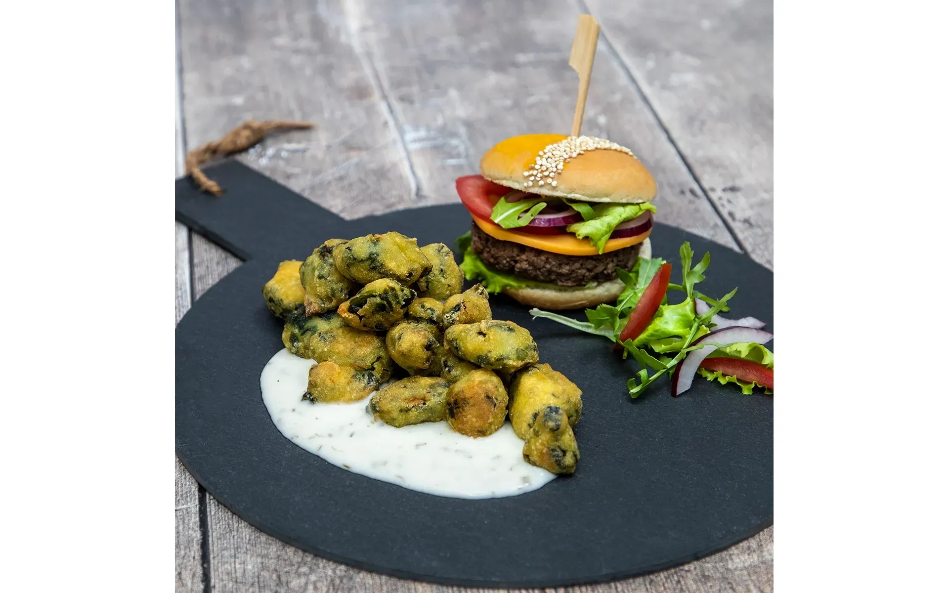 Hamburger Orogel succulento, servito con un contorno di patatine e una salsa gustosa.