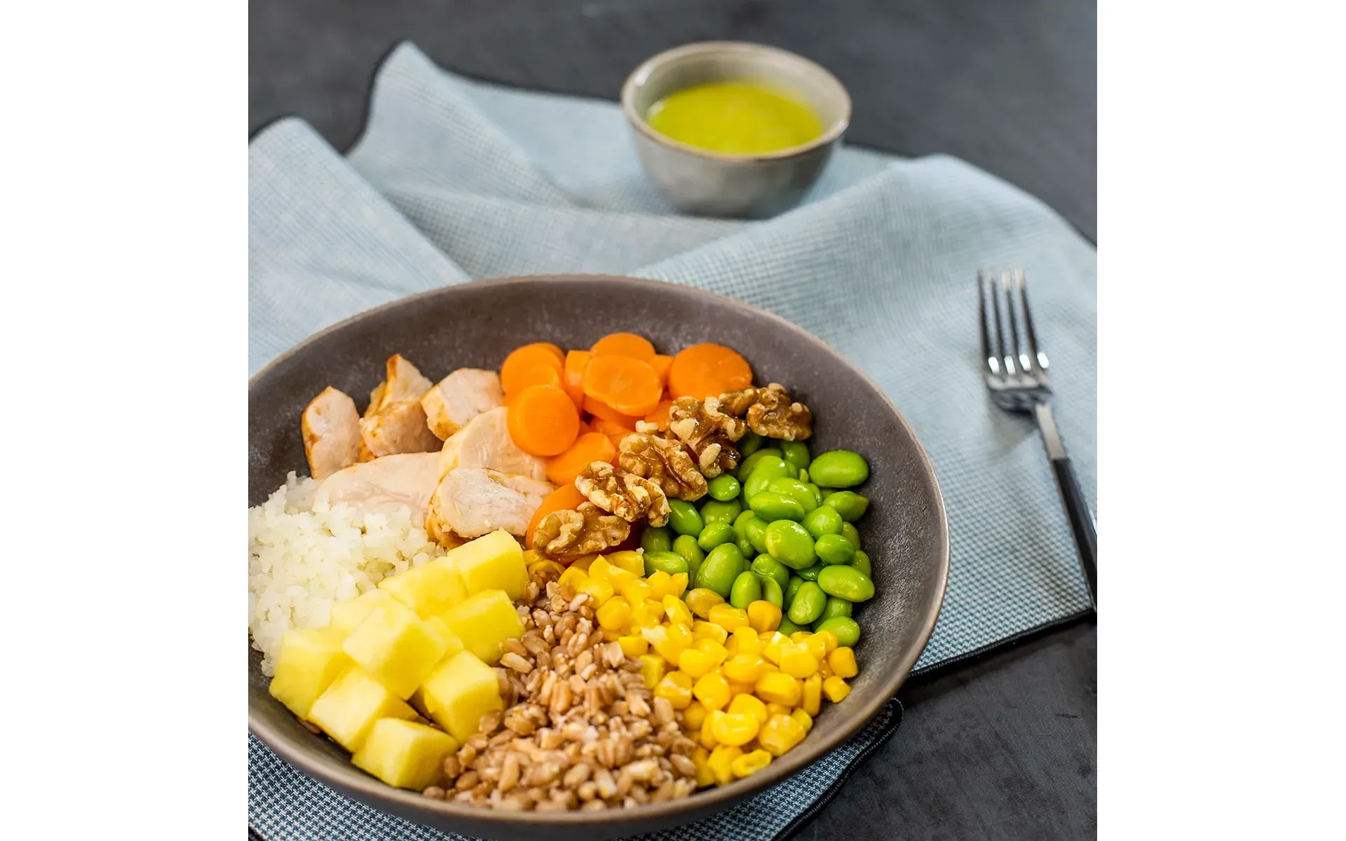 Poke fit Orogel: una ciotola leggera e nutriente con riso, carote, piselli e altri ingredienti sani.