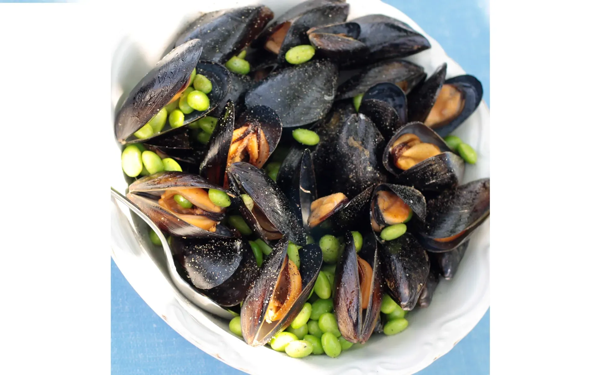 ImpA pan of delicious peppered mussels, an Orogel recipe with an original twist.epata di cozze Orogel, un classico della cucina marinara, con cozze fresche e pepe nero.
