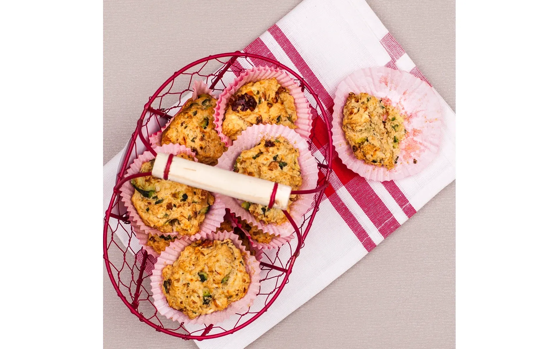 Piatto con una selezione di muffin assortiti, presentati con un elegante tovagliolo rosa.