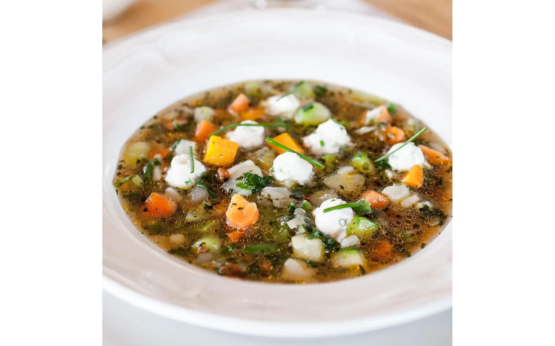 Ciotola di minestrone classico, con un mix di verdure di stagione e una spolverata di formaggio.