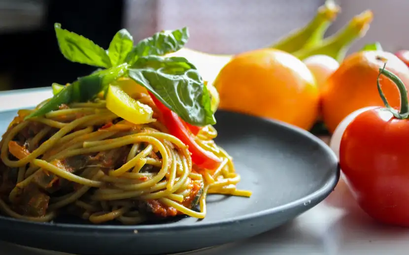 In cosa consiste la dieta mediterranea: un piatto di spaghetti con verdure fresche e pomodori.