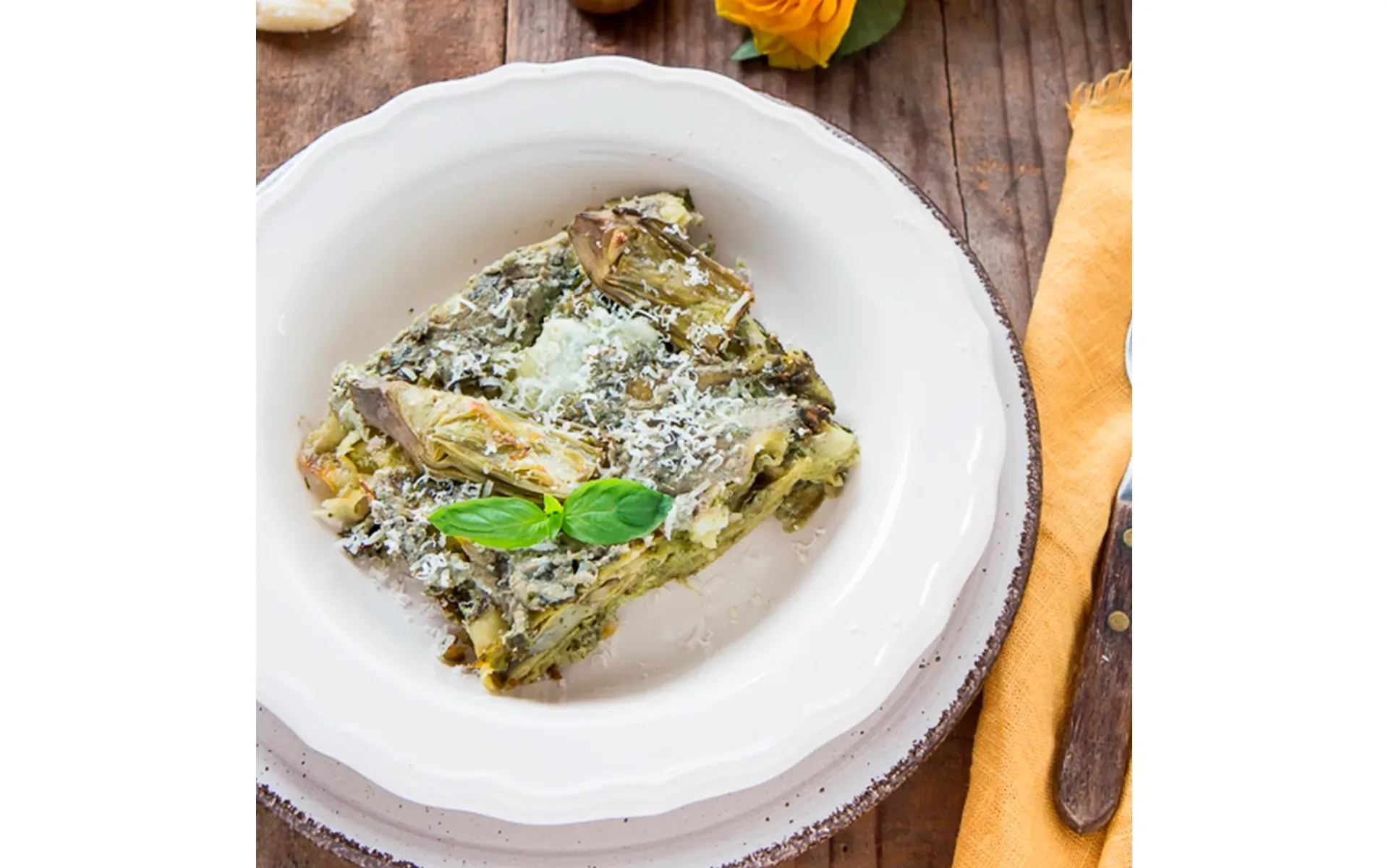 Lasagna Orogel, un classico della domenica, servita su un piatto con forchetta e coltello.