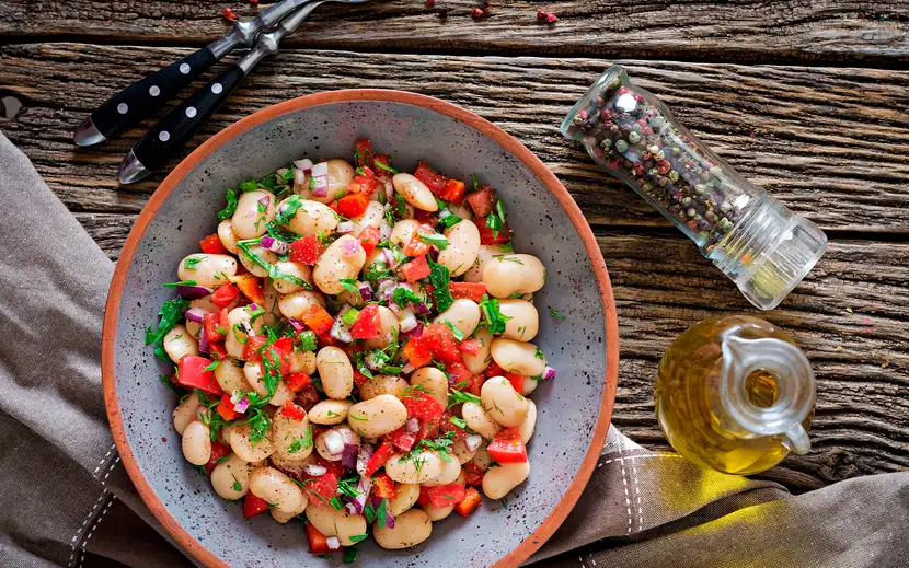 L’immagine mostra una ciotola colma di fagioli cannellini, illustrando l'argomento dell'articolo sui loro benefici.