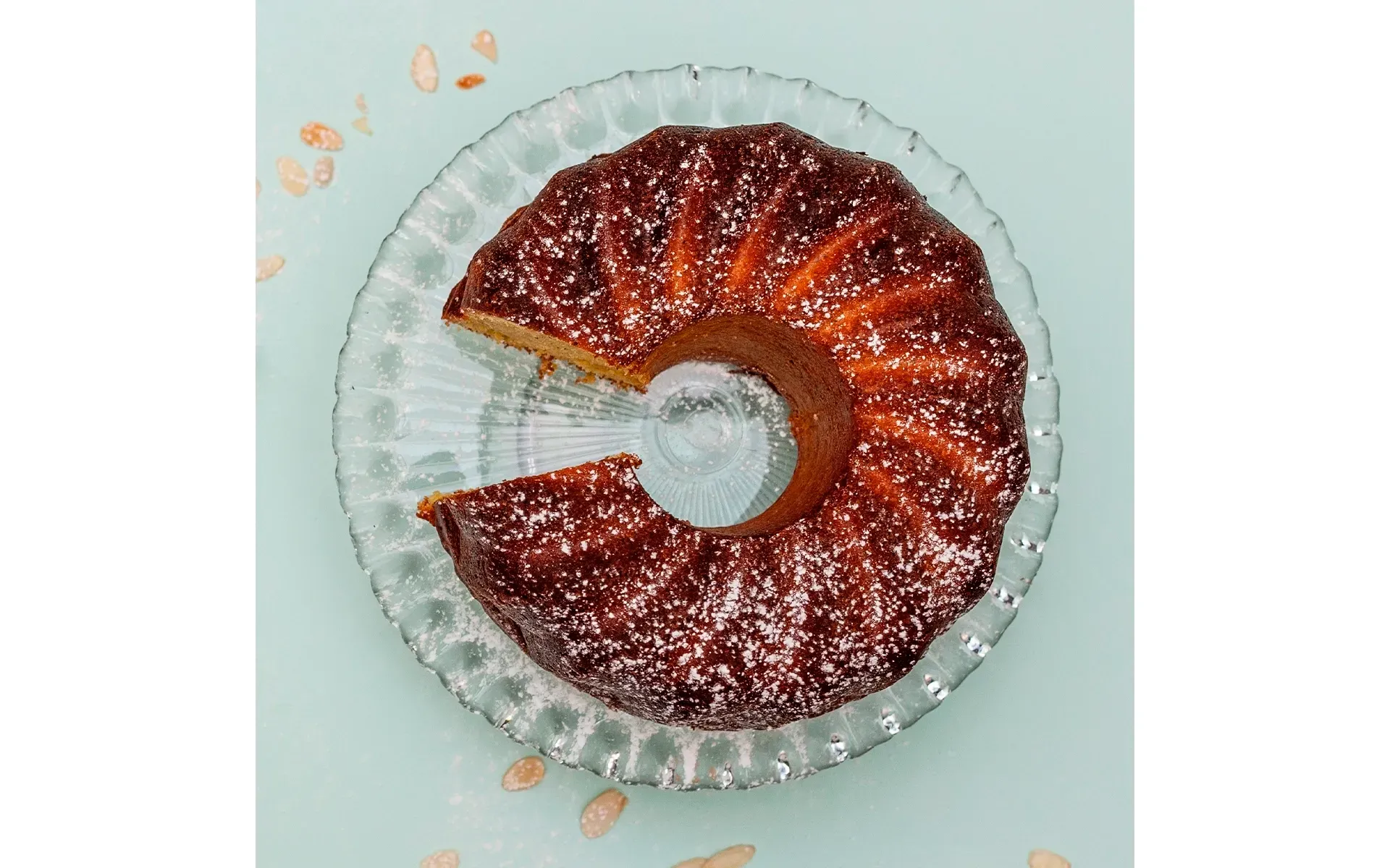 Torta di zucchine e mandorle Orogel, un dolce soffice e originale, con una fetta mancante.