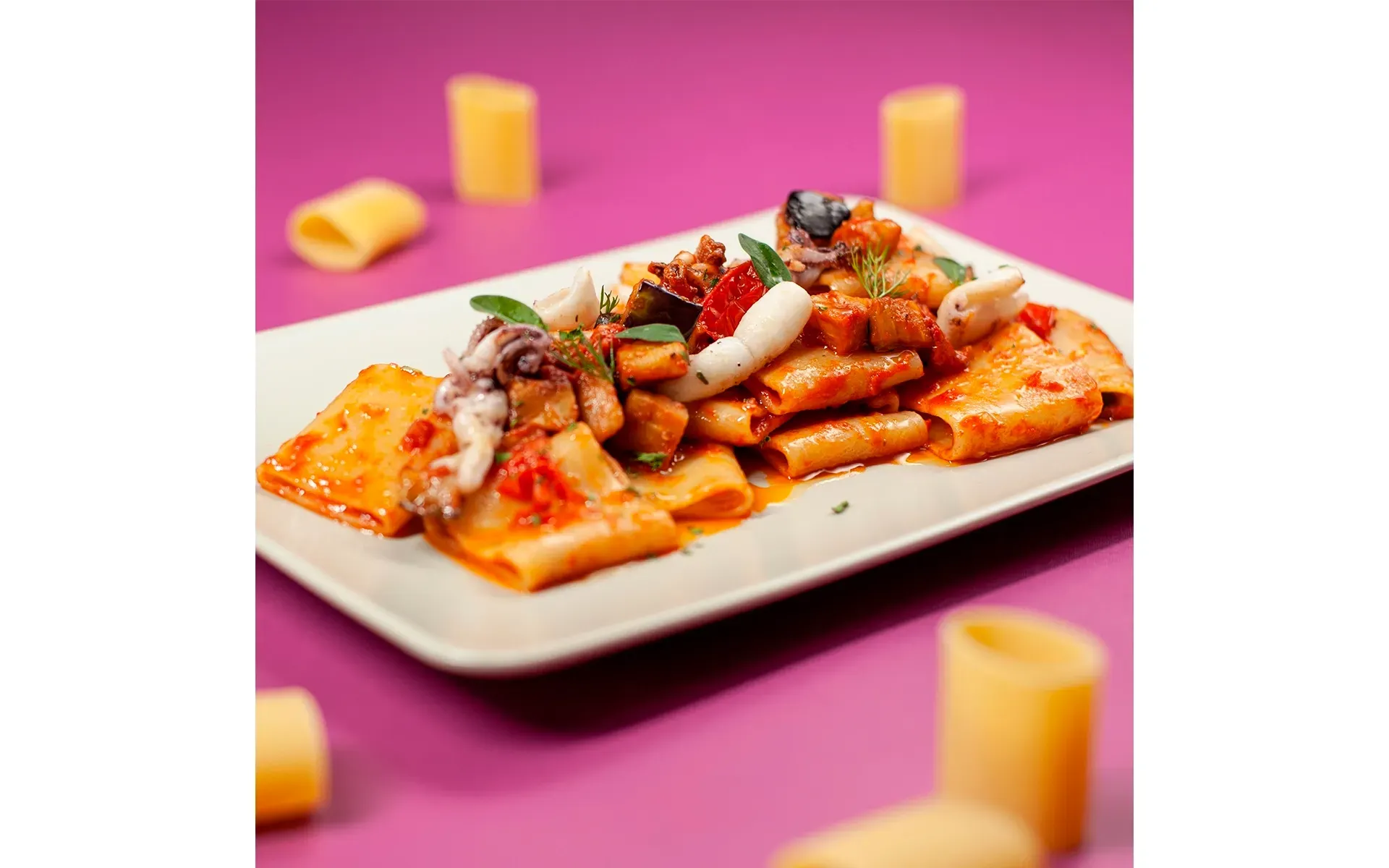 Piatto di pasta con calamari e melanzane: la ricetta Orogel dei paccheri ai calamari, melanzane e olive.