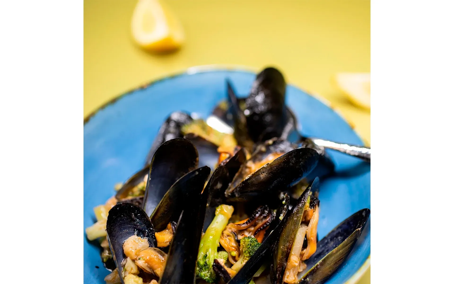 Zuppetta di cozze Orogel, un classico della cucina marinara, servita su un piatto blu con broccoli.