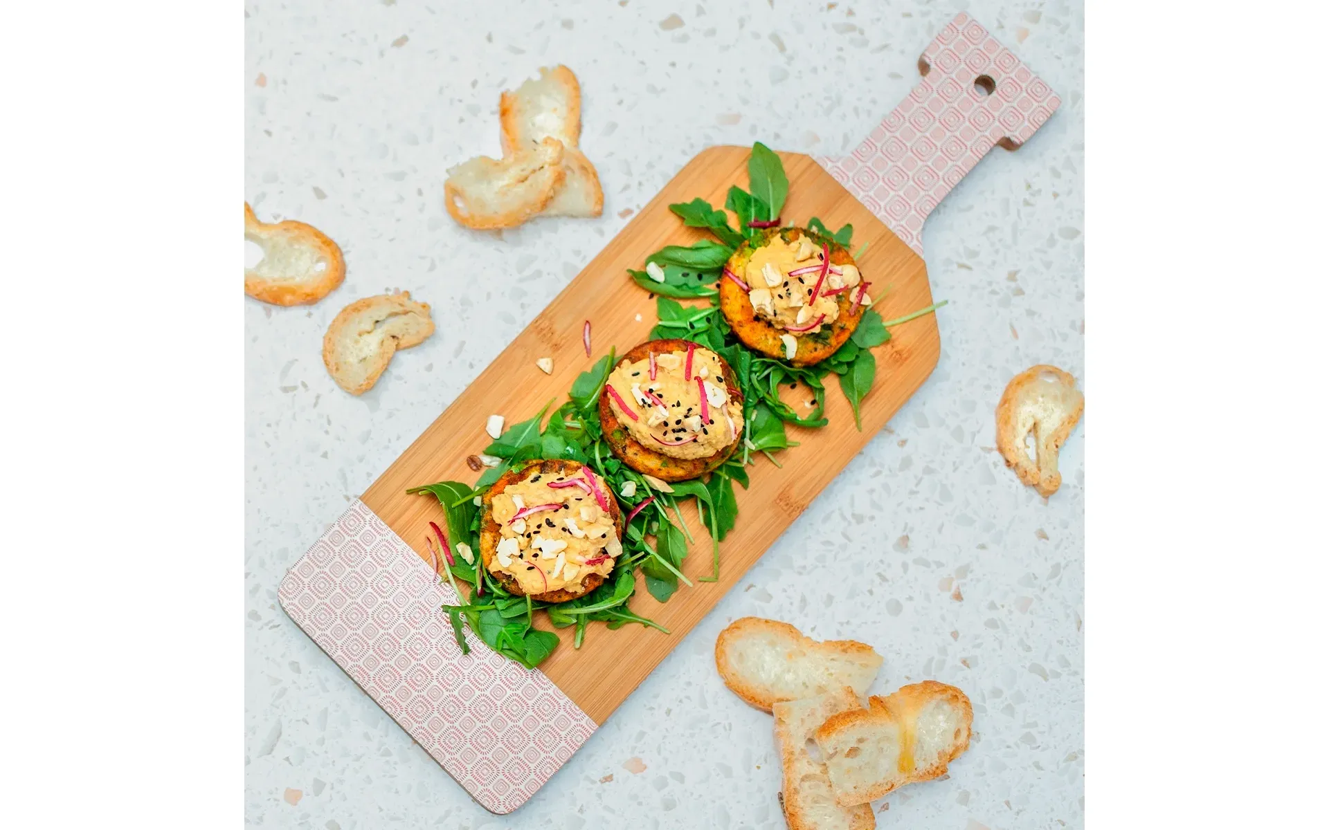 Tortino di verdure Orogel con hummus di ceci, rucola e anacardi: un piatto vegetariano ricco.