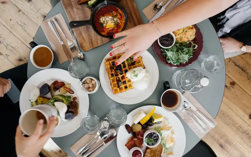 Colazione salata: cosa preparare? Persone che gustano una colazione salata a un tavolo imbandito.