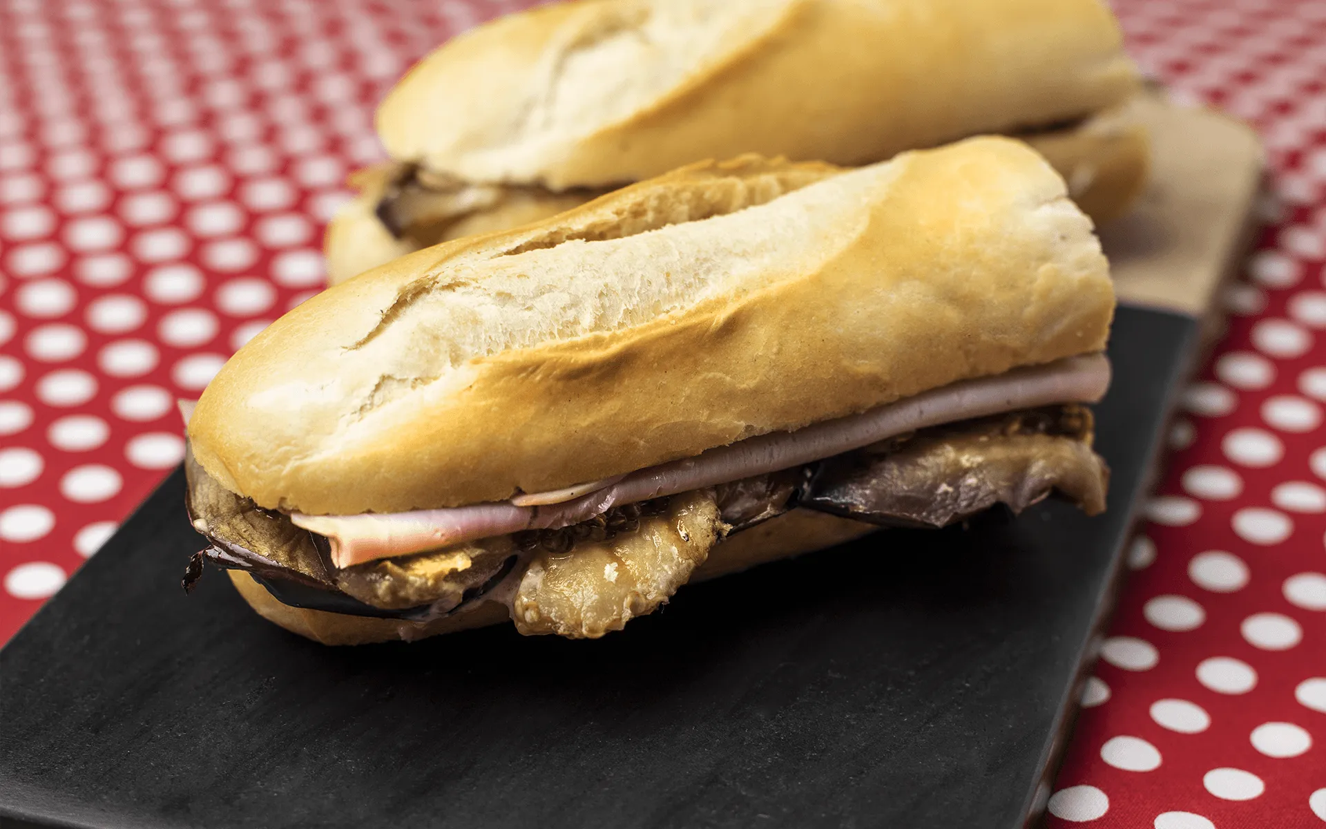 Baguette Orogel farcita con prosciutto cotto di Praga, melanzane e salsa tartara: un panino ricco.