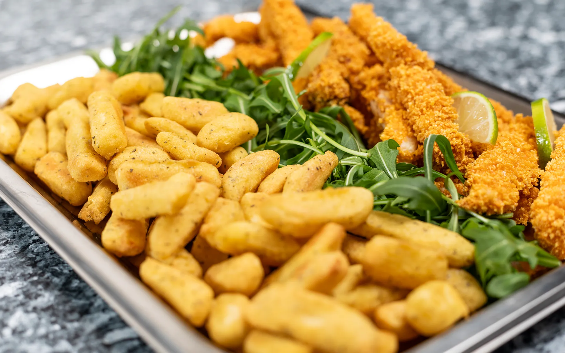 Patate Orogel con merluzzo: un piatto di pesce fritto e patatine, con verdure e limone.