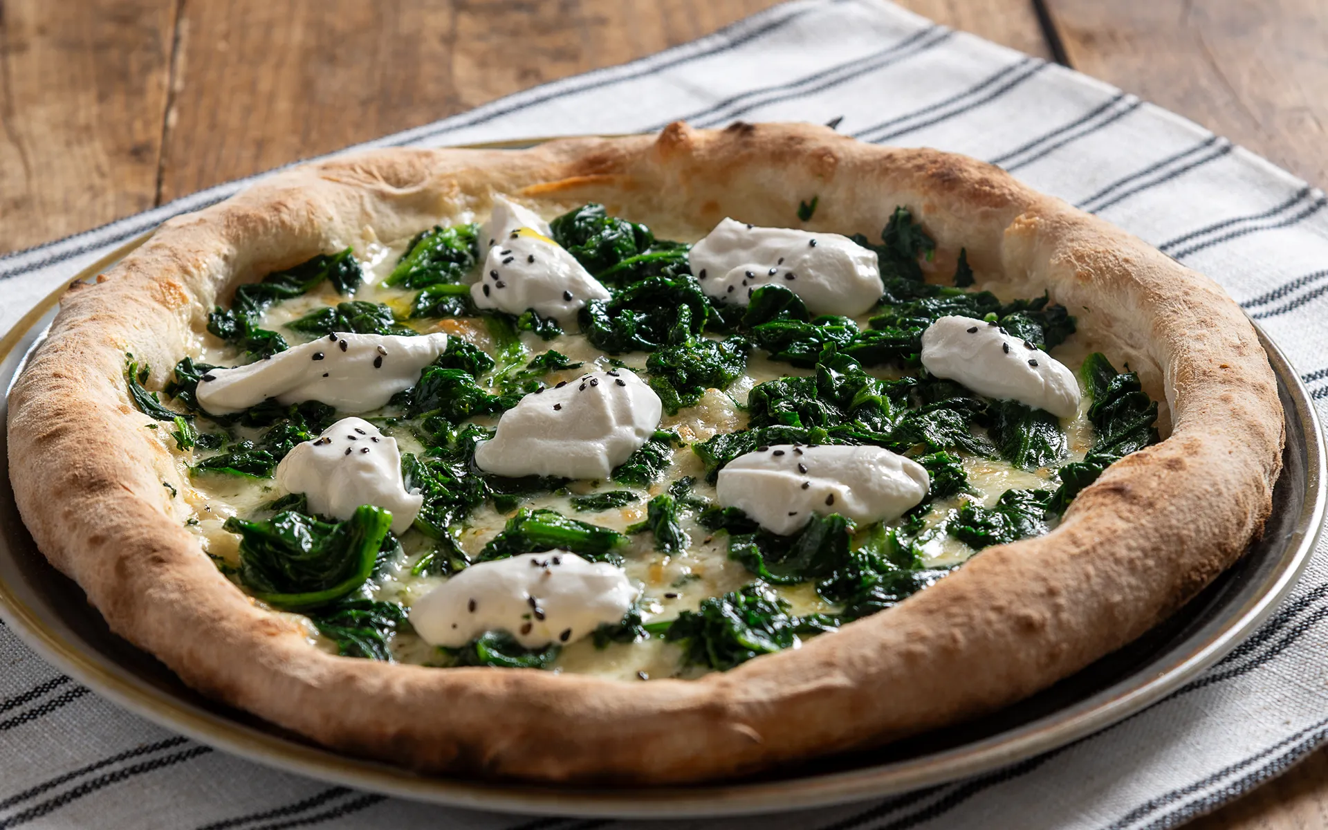 Pizza con mozzarella filante, spinaci e burrata cremosa, dal gusto delicato ed equilibrato.