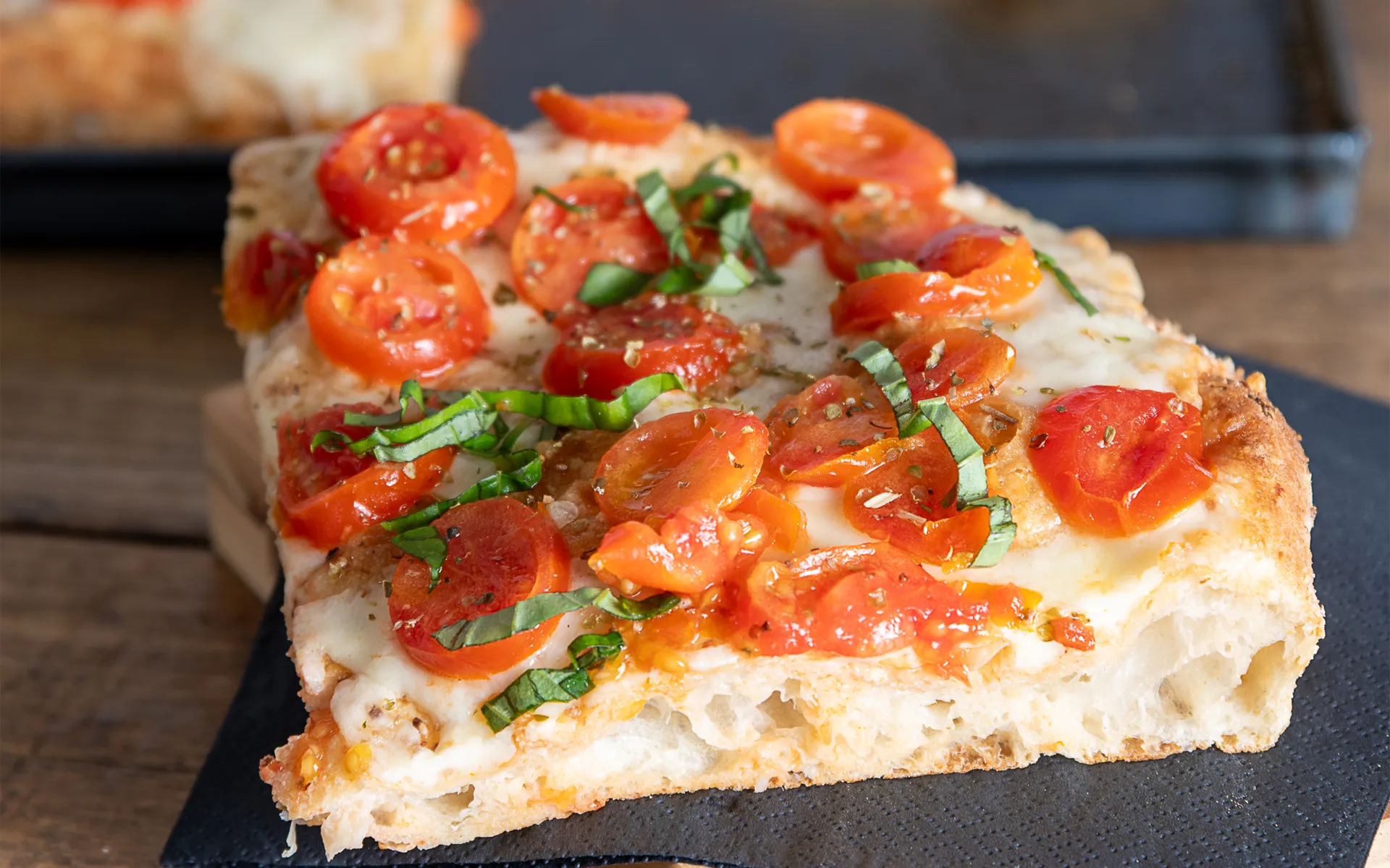 Pizza tonda classica con pomodoro, parmigiano grattugiato e prezzemolo, dal profumo fresco e tradizionale.