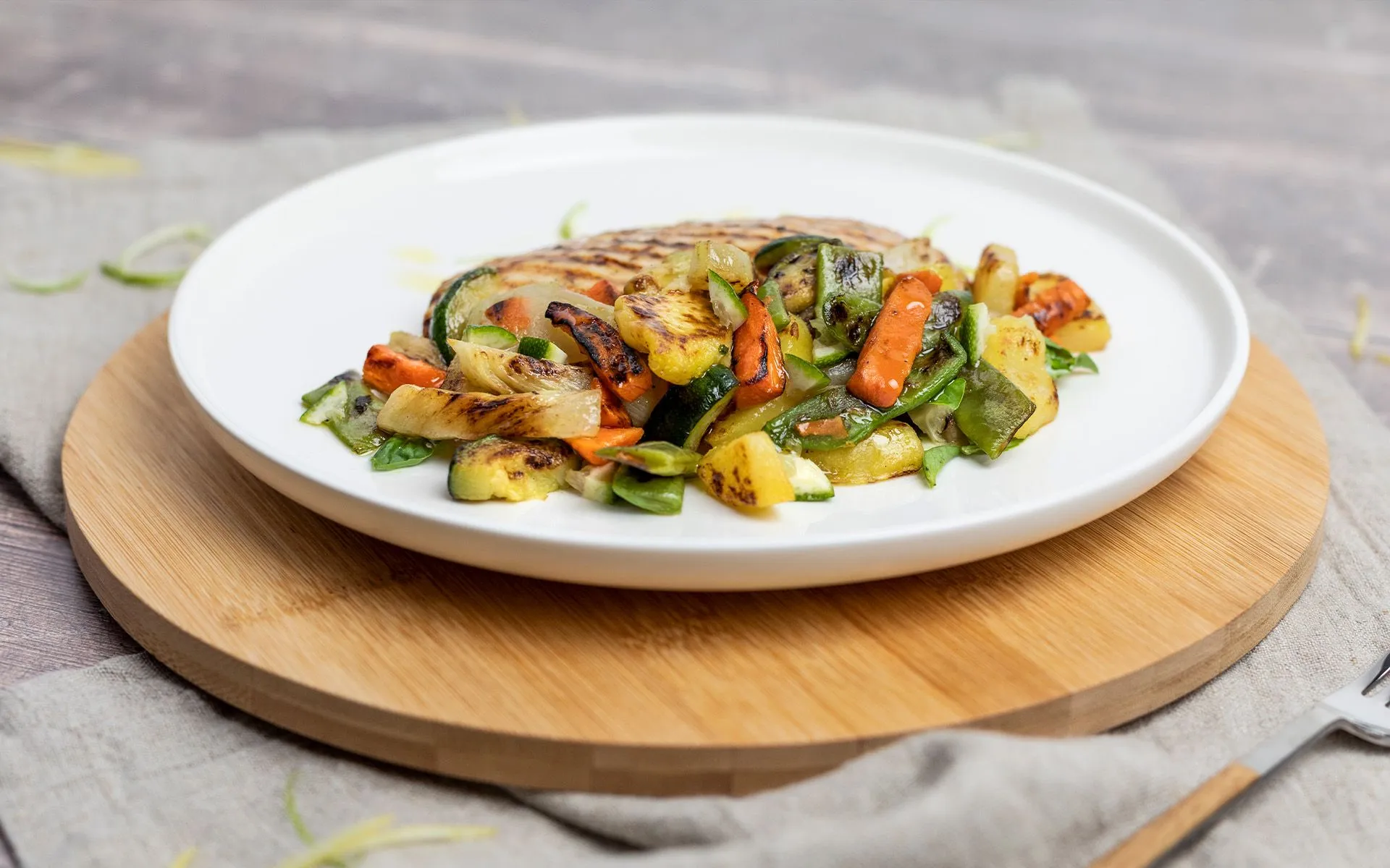 Creare armonia in tavola: un piatto con verdure colorate e pollo, su un tavolo di legno.