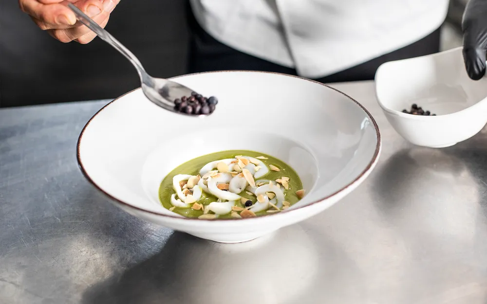 Chef Orogel al lavoro: una persona mescola ingredienti in una ciotola con un cucchiaio.