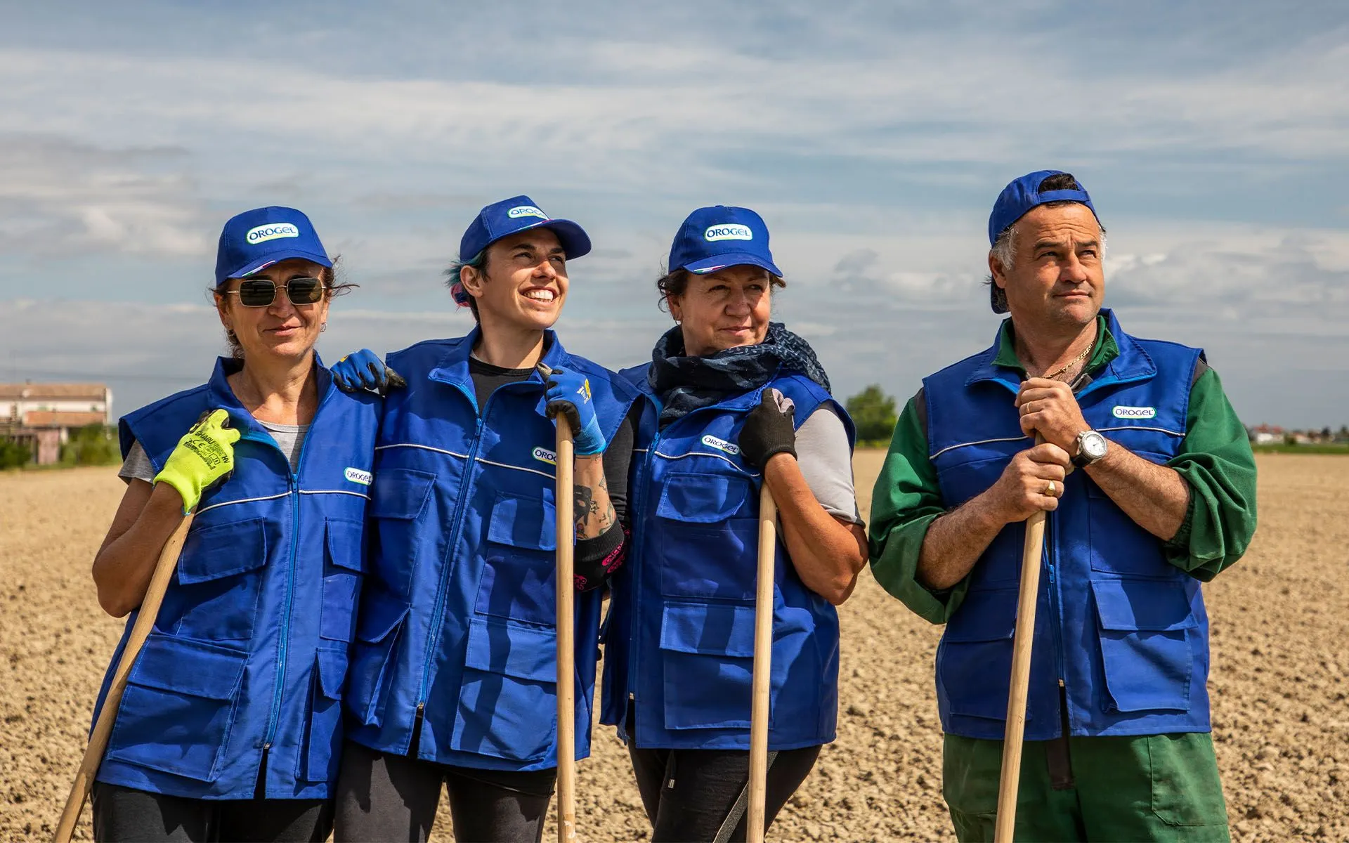 Processo di coltivazione Orogel (box ultimo): tre agricoltori al lavoro nel campo con pale.