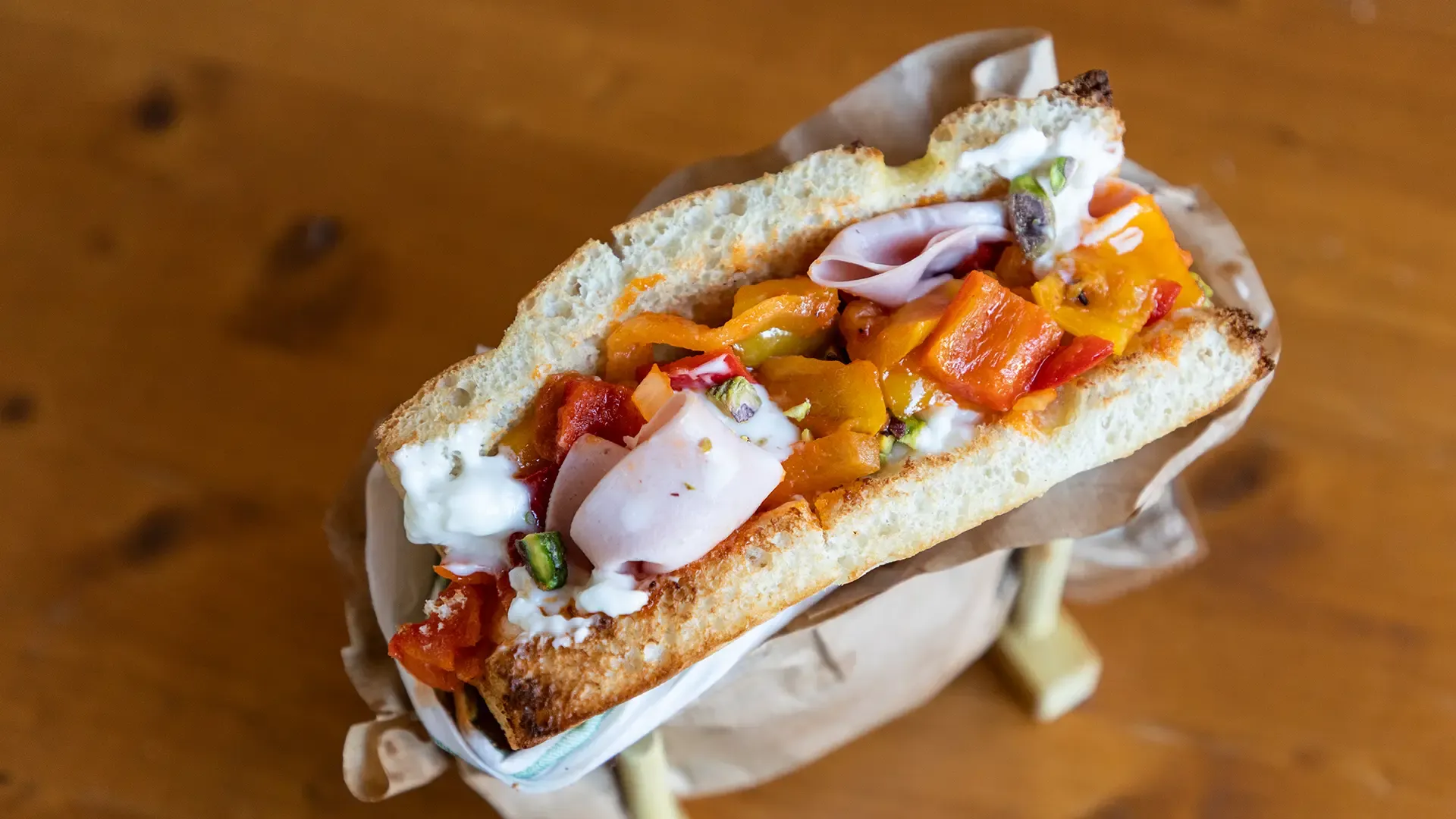 Focaccia con peperonata e mortadella servita con granella di pistacchi