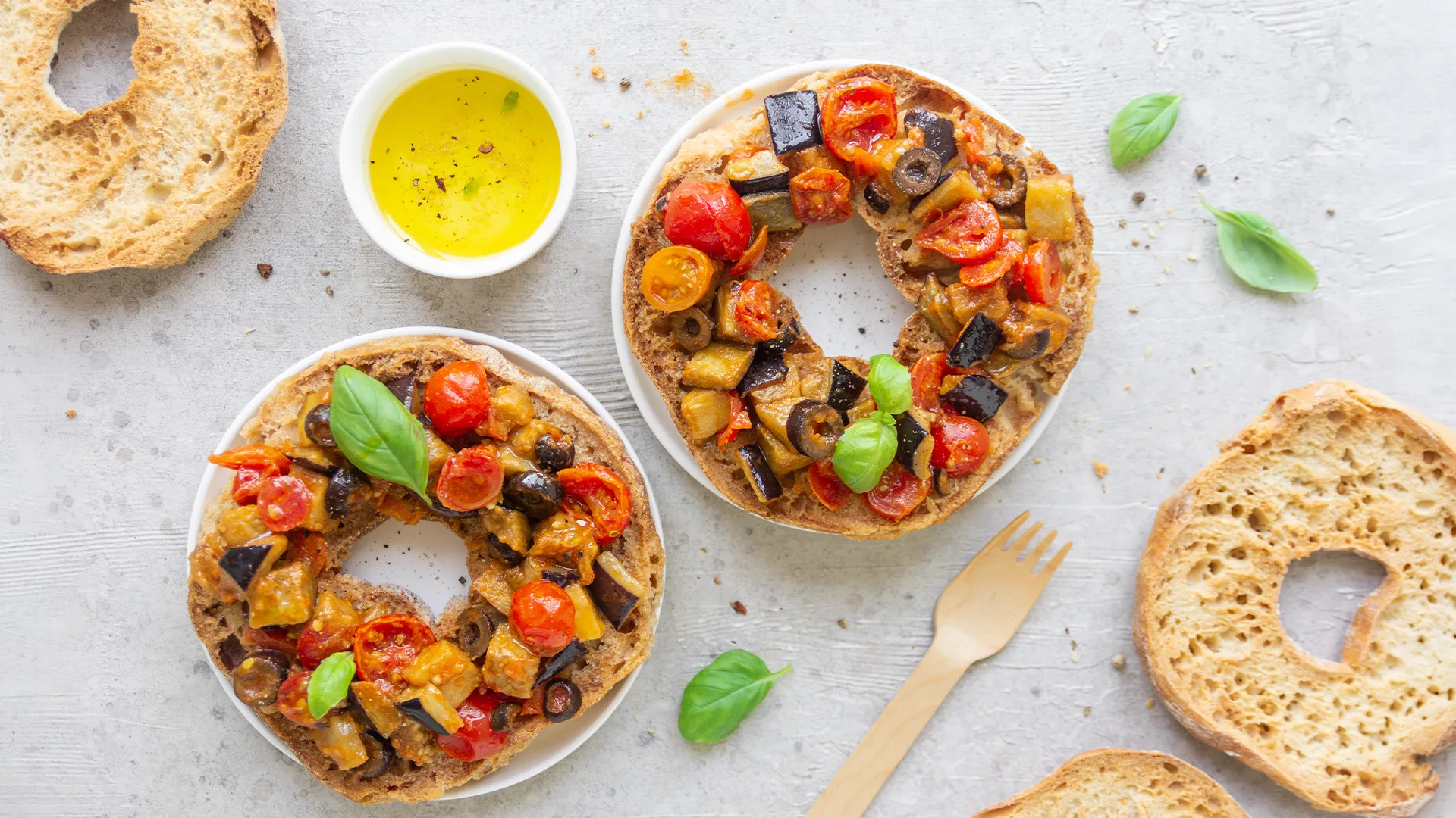 Due friselle condite con verdure grigliate (melanzane, pomodorini, olive) e basilico fresco, accompagnate da olio extravergine d’oliva.