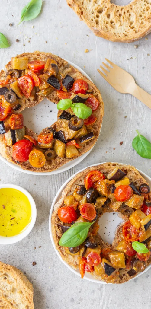 Due friselle condite con verdure grigliate (melanzane, pomodorini, olive) e basilico fresco, accompagnate da olio extravergine d’oliva.