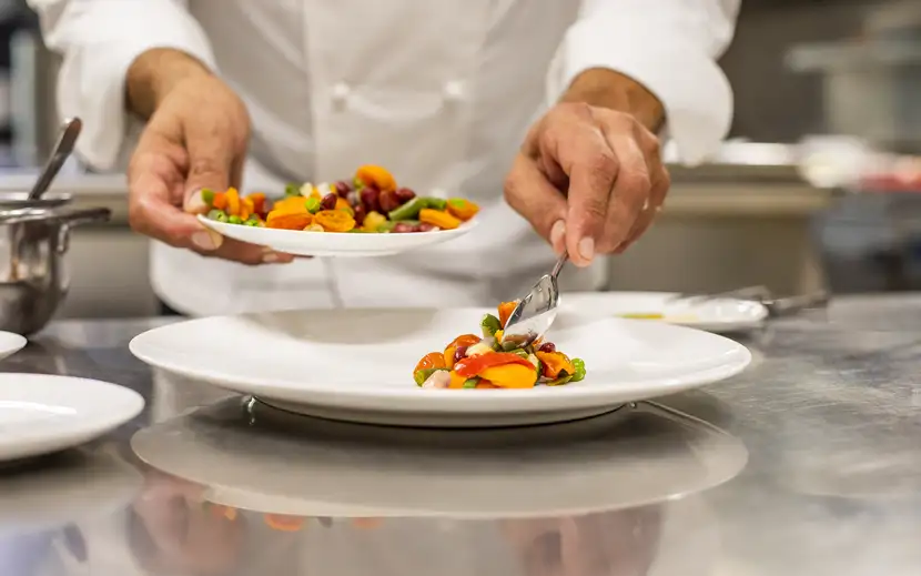 Intervista a Davide Giambruno per Orogel: lo chef prepara un piatto in cucina.