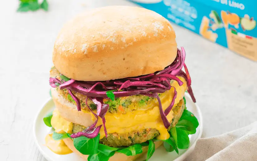 Invitante maxi burger servito in un panino soffice, con tutti i condimenti classici.