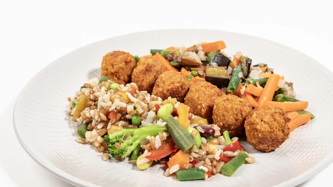 Polpettine proteiche Orogel, ideali per sportivi, servite con riso e verdure.