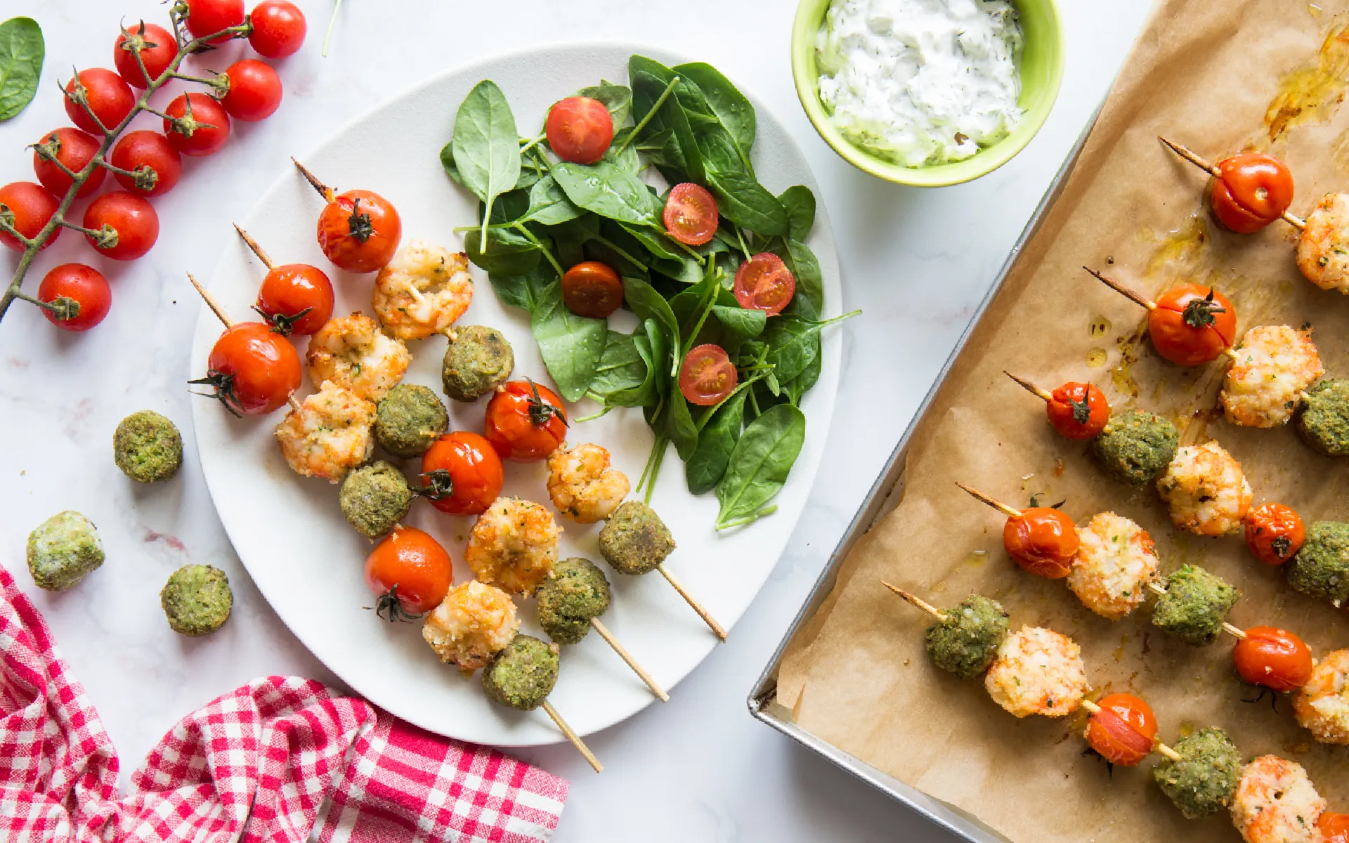 Spiedini Orogel di gamberi con pomodorini freschi e spinaci novelli, un piatto colorato.