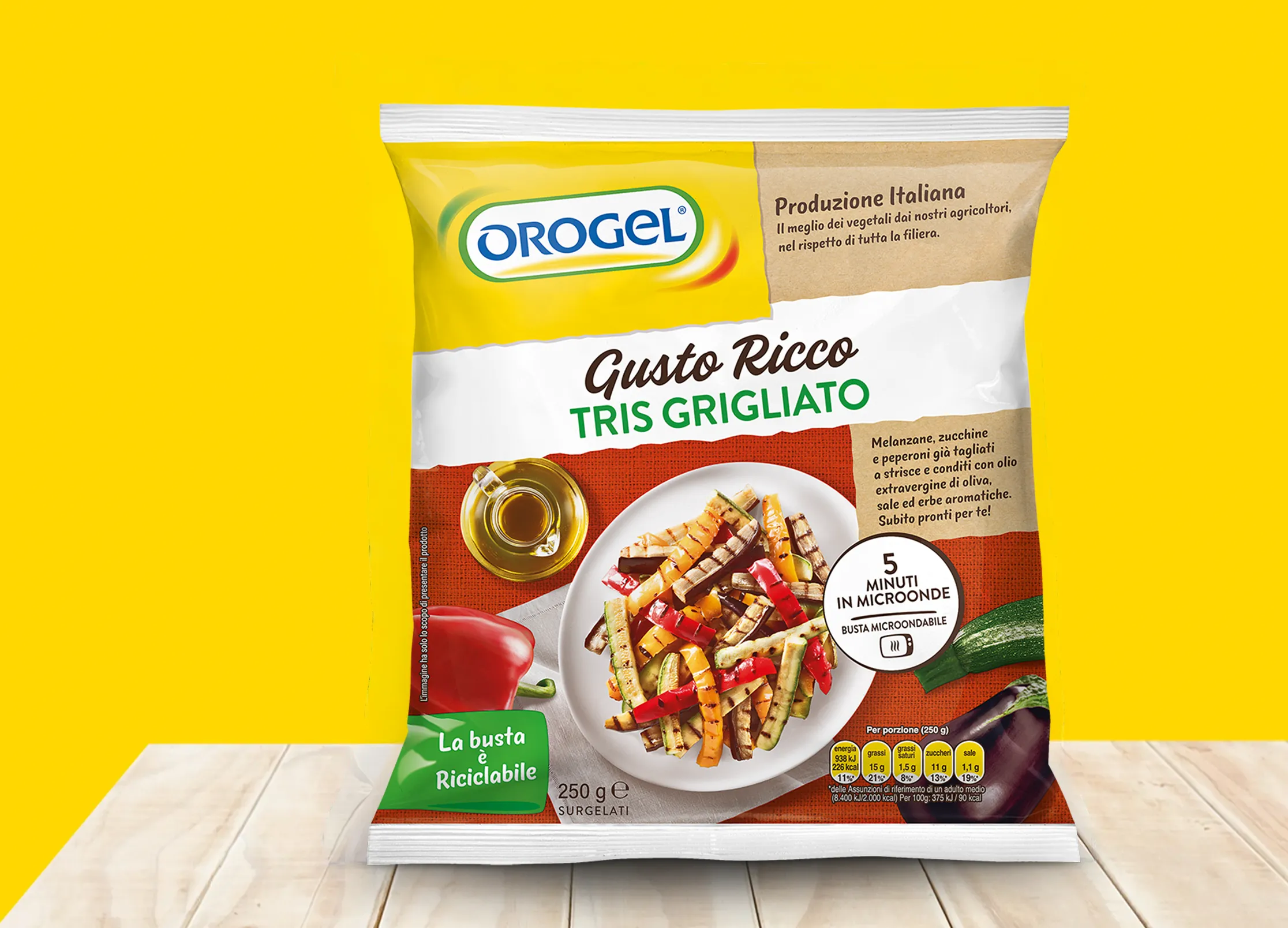 Busta di verdure surgelate Orogel “Gusto Ricco Tris Grigliato” con melanzane, zucchine e peperoni grigliati, su sfondo giallo.