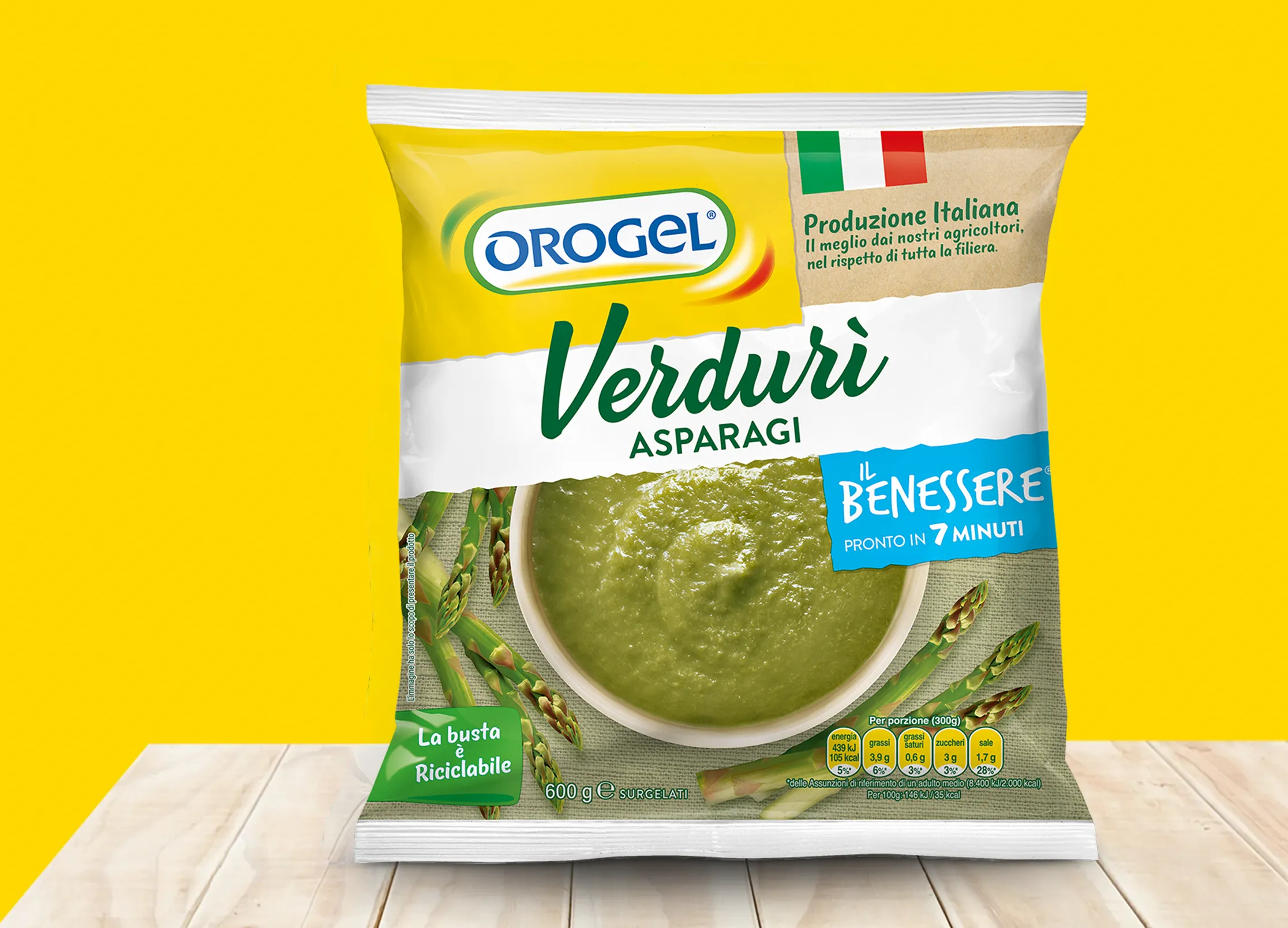 Busta di verdure surgelate Orogel “Verduri Asparagi Il Benessere”, crema di asparagi pronta in pochi minuti, su sfondo giallo.