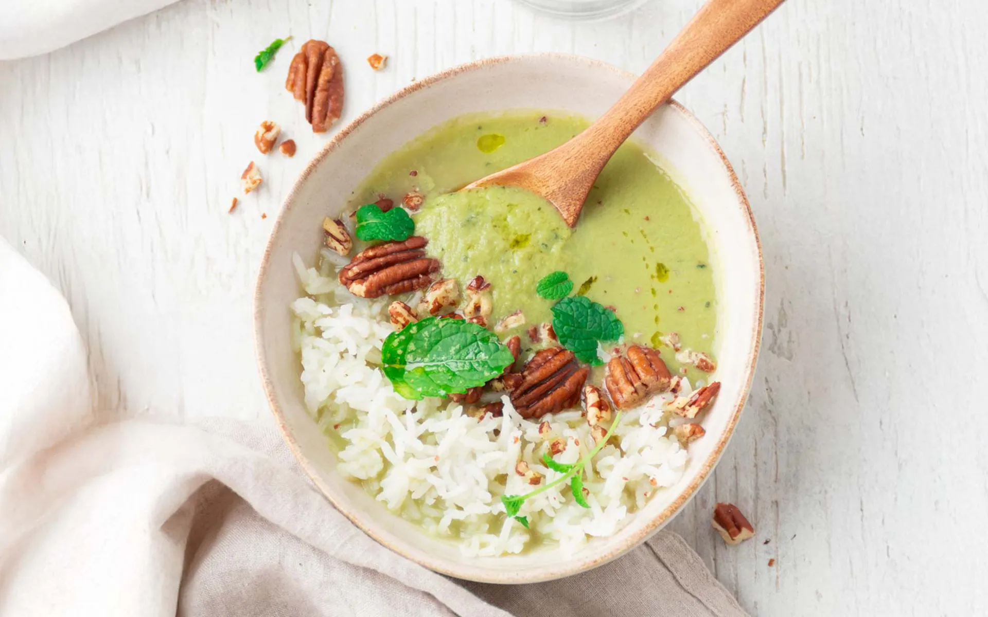 Bowl con riso, passato di verdure, noci pecan e foglie aromatiche.
